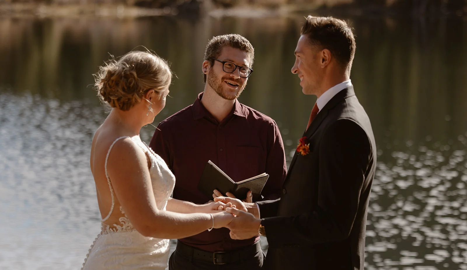 Officiant with couple at a Colorado lake ceremony