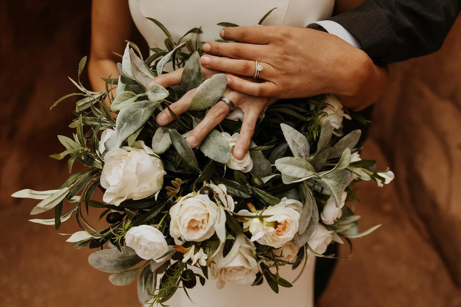 Close-up of wedding rings resting on a vibrant flower bouquet