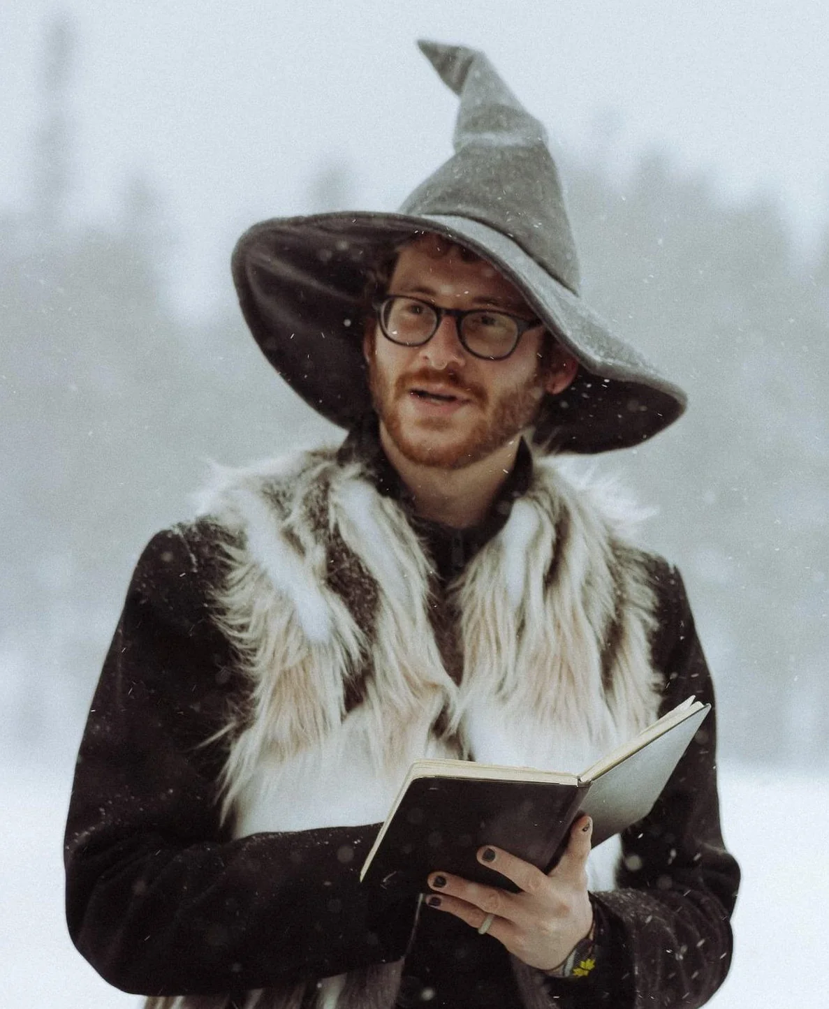 Officiant AJ during ceremony, smiling with vows tablet